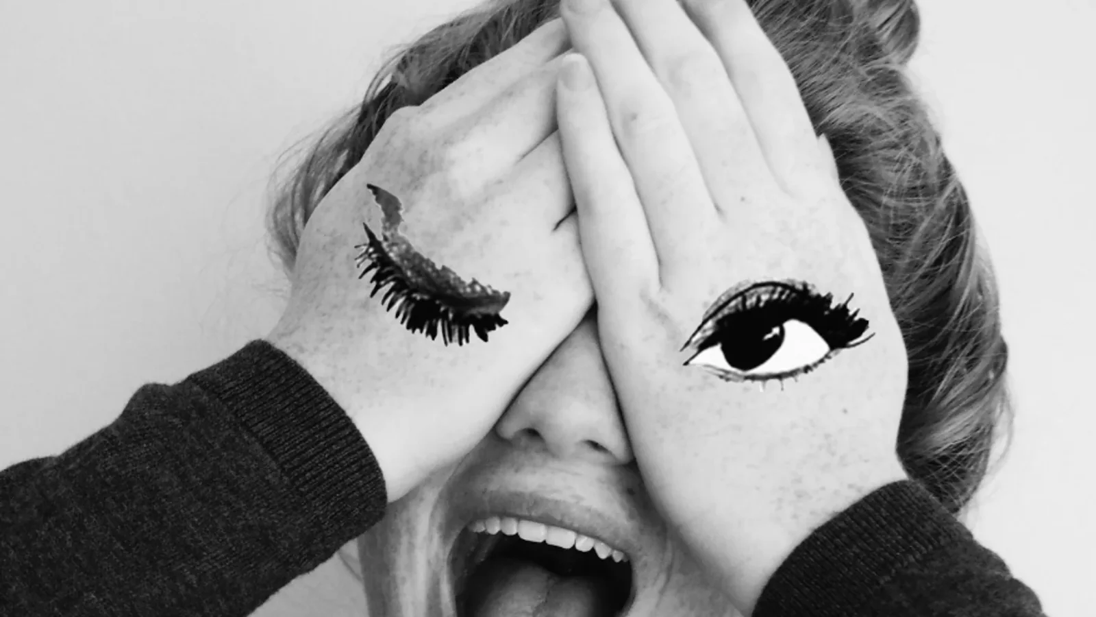 Black-and-white portrait with illustrated eyes painted across raised hands